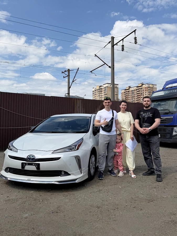 Клиенты GOOD AUTO рядом с Toyota Prius при выдаче автомобиля